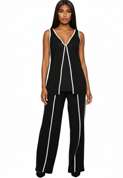 Woman wearing a black sleeveless top and pants with white piping on a white background
