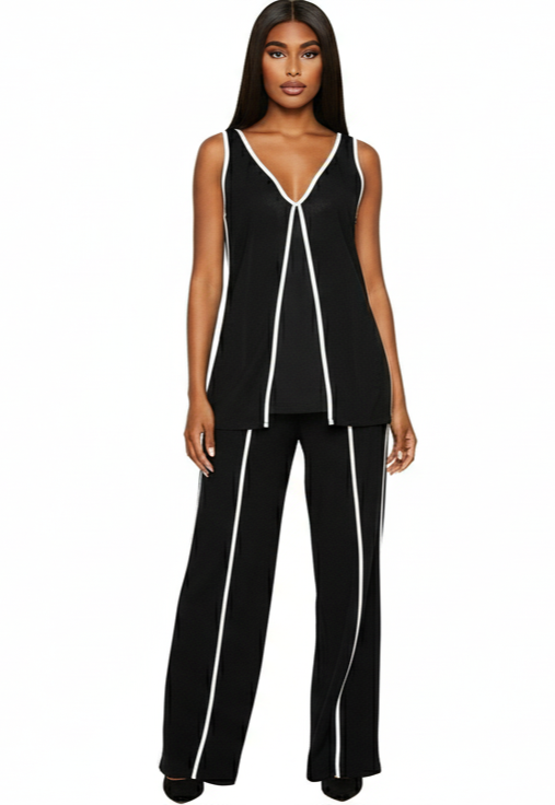 Woman wearing a black sleeveless top and pants with white piping on a white background