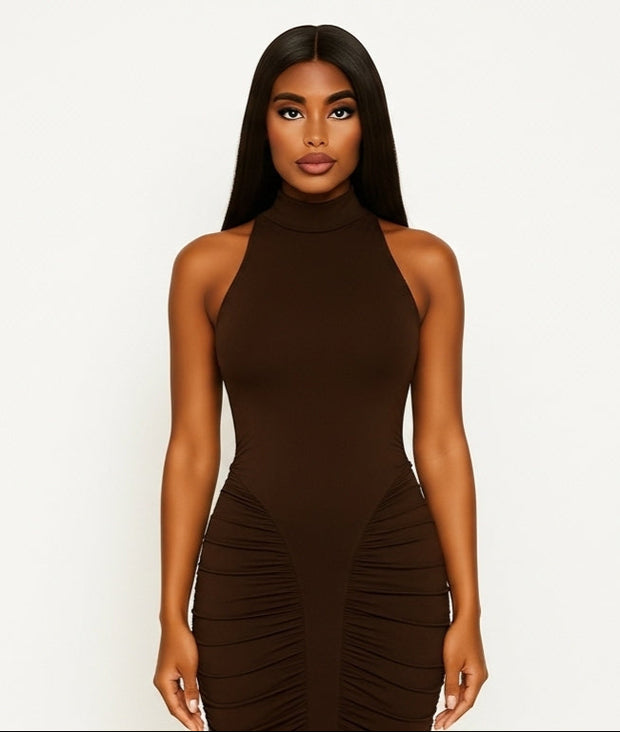 Woman wearing a brown halter neck dress with ruched sides on a white background