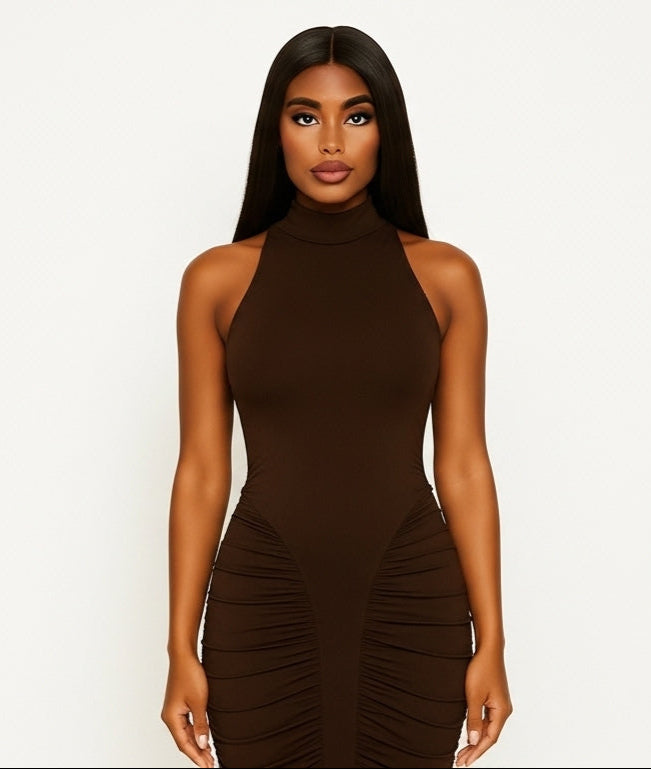 Woman wearing a brown halter neck dress with ruched sides on a white background