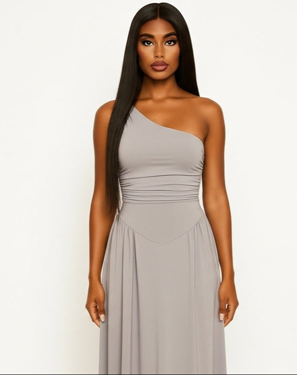 Woman wearing a one-shoulder gray dress on a white background