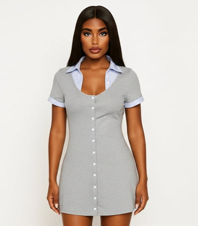Woman wearing a gray button-up dress against a white background