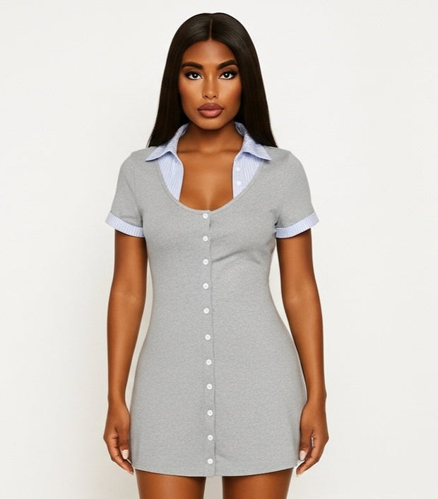 Woman wearing a gray button-up dress against a white background
