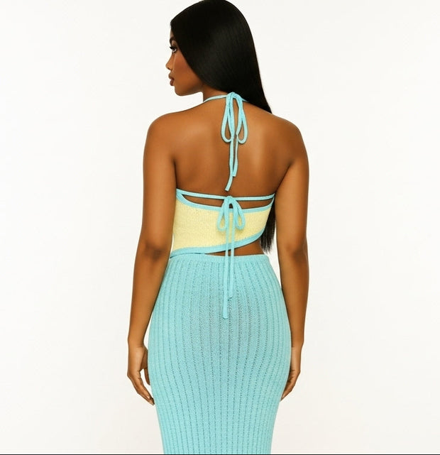 Woman wearing a yellow top and teal skirt on a white background