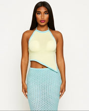 Woman wearing a yellow top and teal skirt on a white background