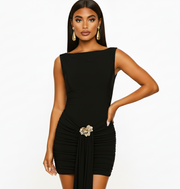 Woman wearing a black dress with a brooch on a white background
