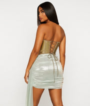 Woman wearing a strapless top and light-colored skirt on a plain background