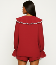 Red outfit with white trim on a plain background