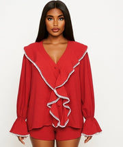 Woman wearing a red outfit with white trim on a white background