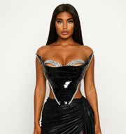 Woman wearing a black outfit with a sheer overlay on a white background