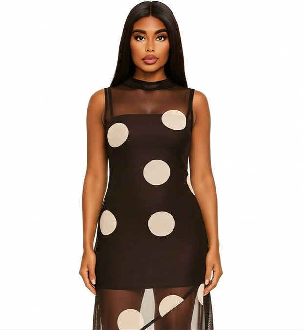 Woman wearing a brown dress with white polka dots on a plain 
