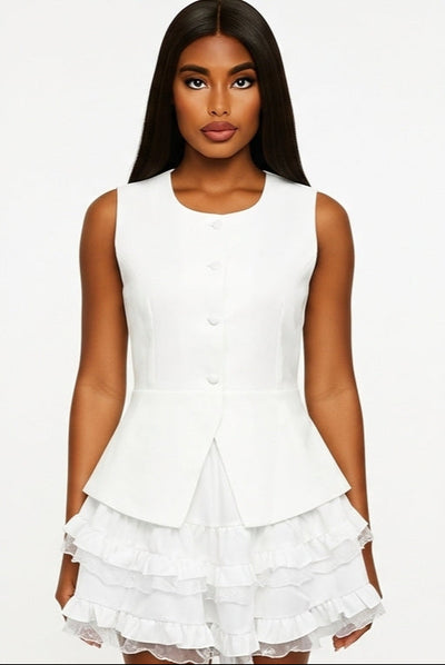 Woman wearing a white sleeveless dress with ruffled layers on a white background