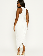 Woman wearing a white sleeveless dress on a plain background