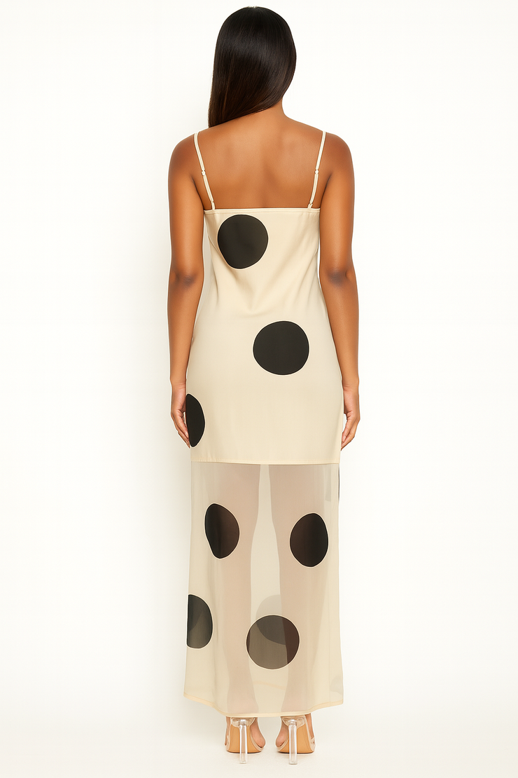 Woman wearing a beige slip dress with black polka dots on a white background