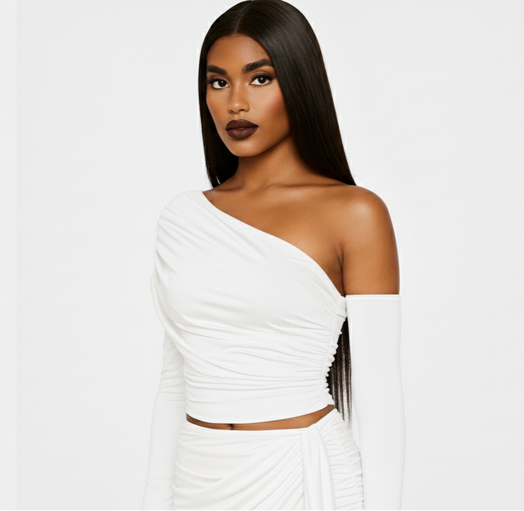 Woman wearing a white one-shoulder dress against a plain background